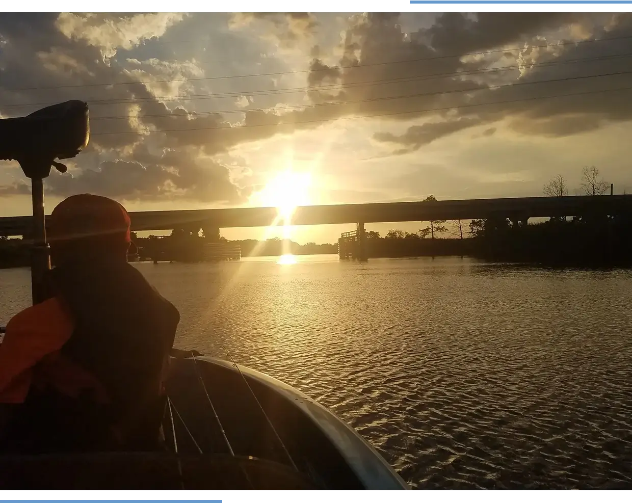 Person on boat during sunset, calm river.