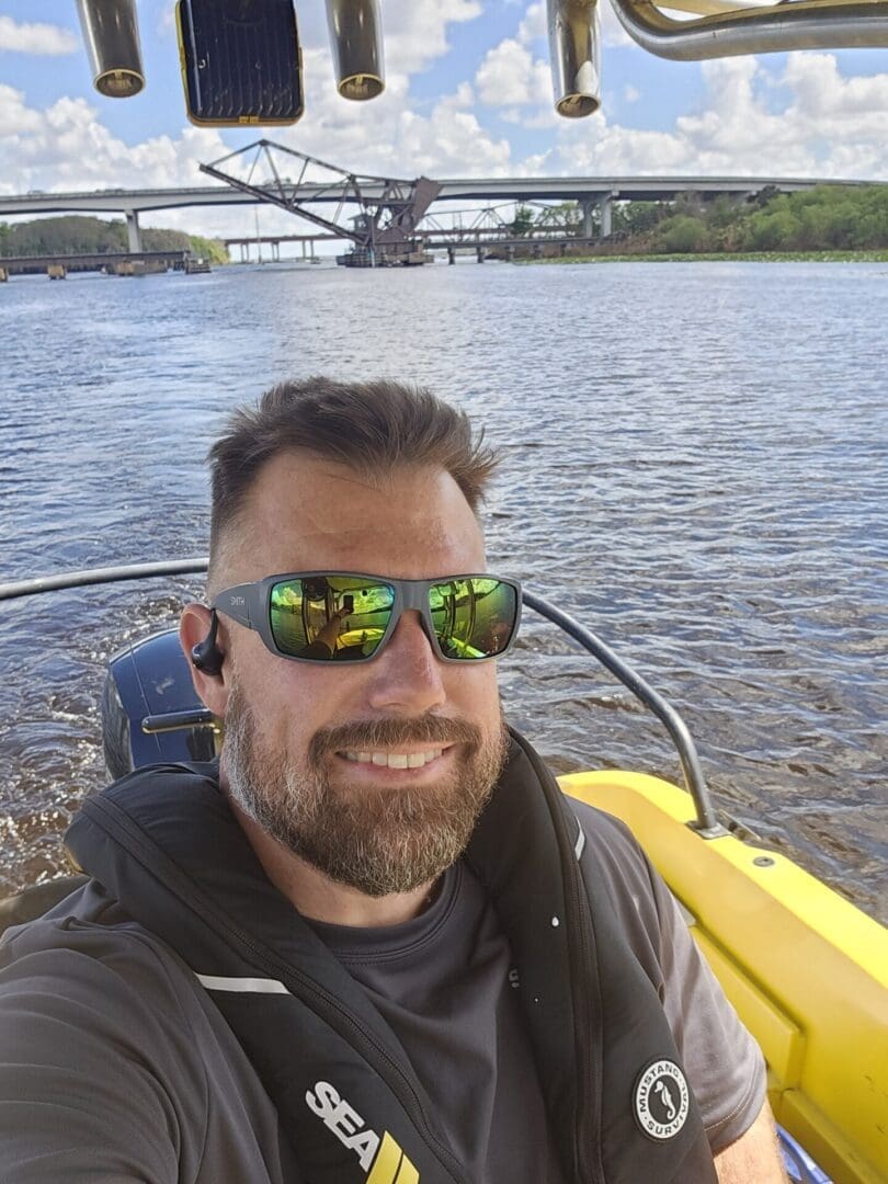 Smiling man wearing sunglasses on a boat